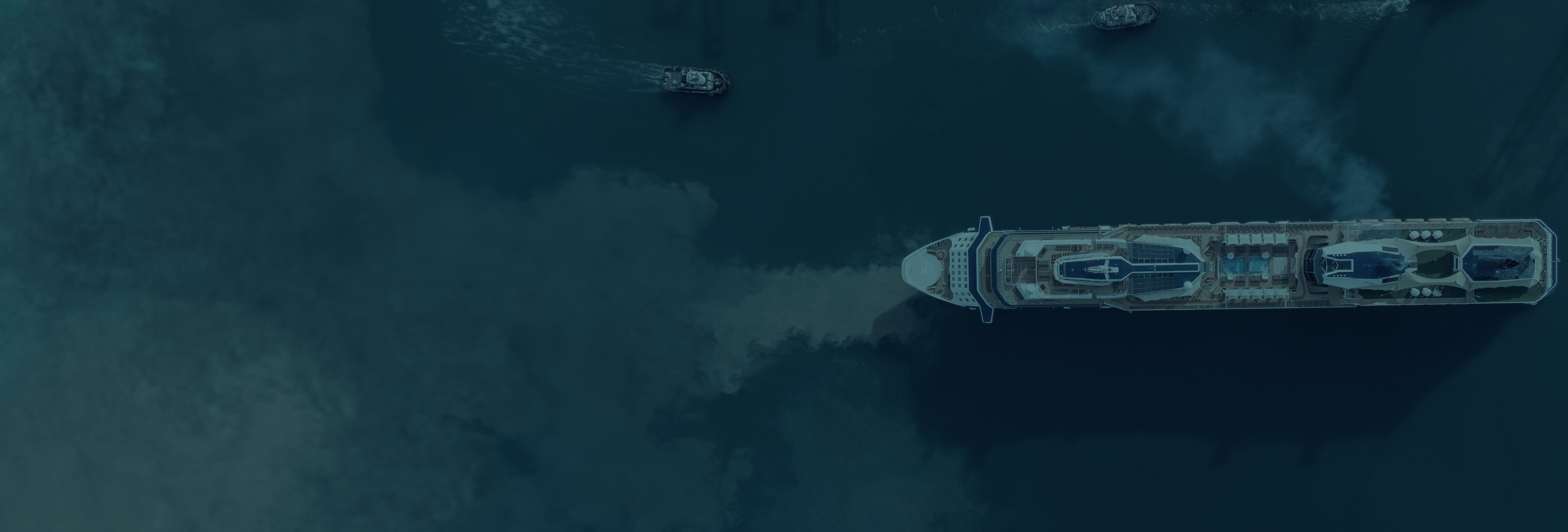 Aerial view of a cruise vessel under way with tug escort